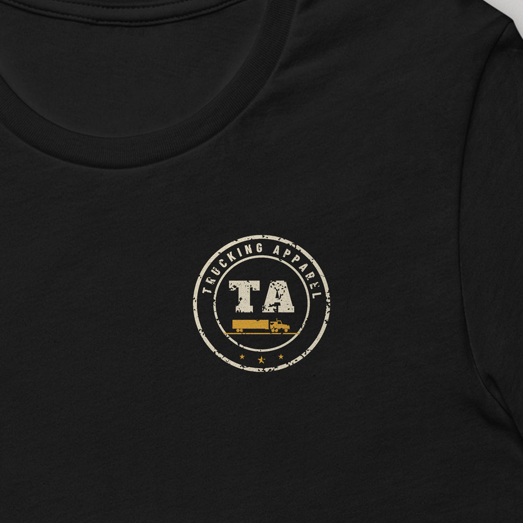 48 States. One Seat. Trucker Tee in black, close-up of the left-chest Trucking Apparel badge. Design made with AI assistance.