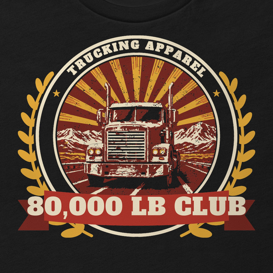 80,000 LB Club Trucker Tee in black, close-up of the front print: 80,000 LB CLUB badge print with a semi truck and laurel wreath. Design made with AI assistance.