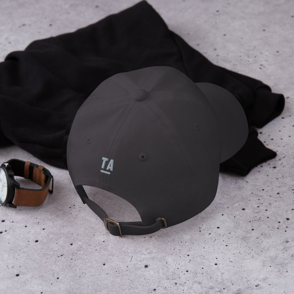 Fluent Dad Cap in dark grey, back view on a dark shirt with a wristwatch.
