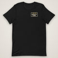 I Am the Supply Line Tee in black, front view laid flat with the bold I AM THE SUPPLY LINE. stencil block on the left chest.
