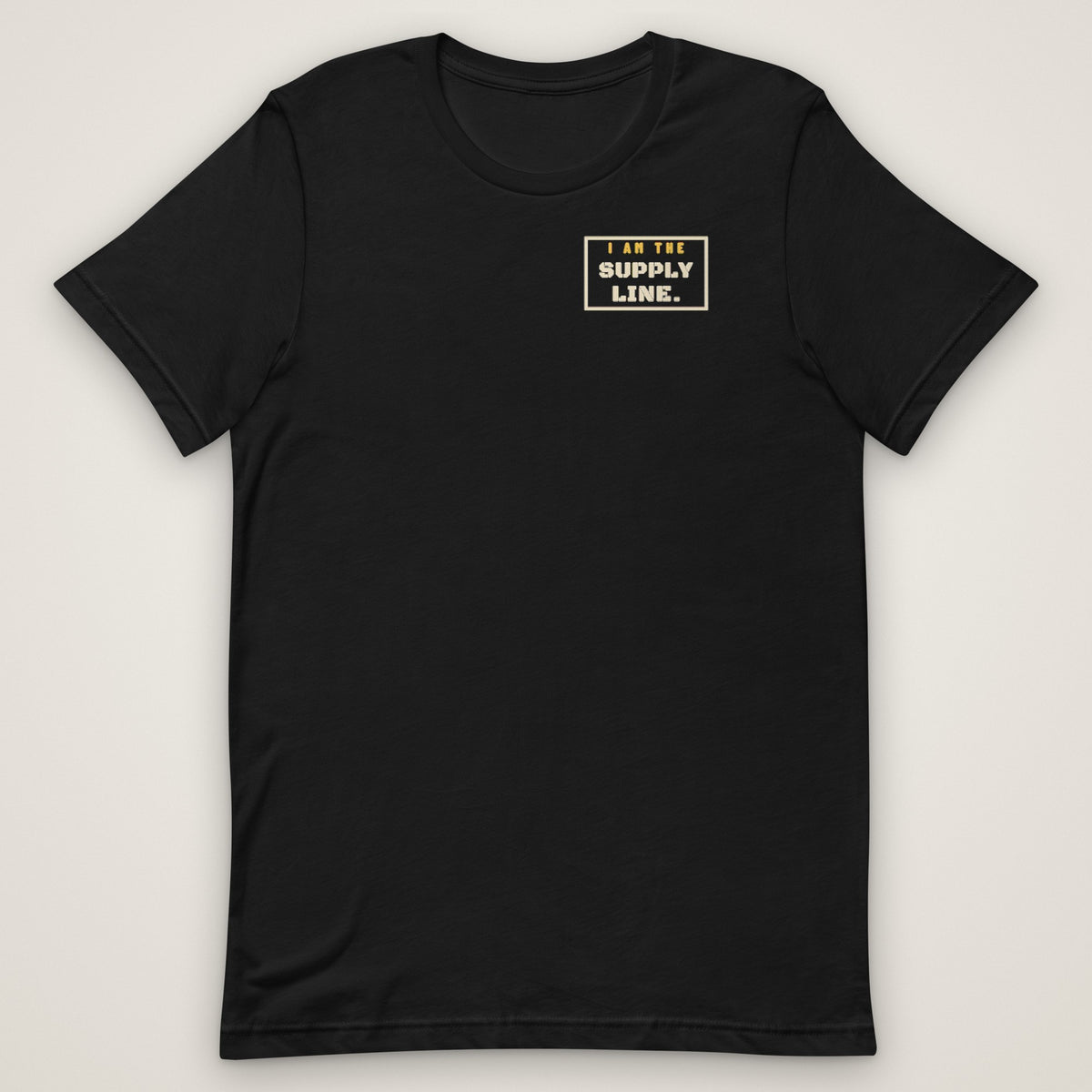 I Am the Supply Line Tee in black, front view laid flat with the bold I AM THE SUPPLY LINE. stencil block on the left chest.