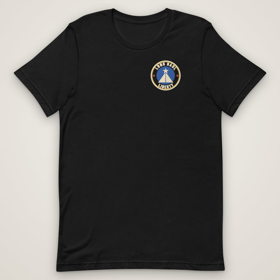 The Nation's Night Shift Tee in black, front view laid flat with the round Long Haul Liberty badge on the left chest.