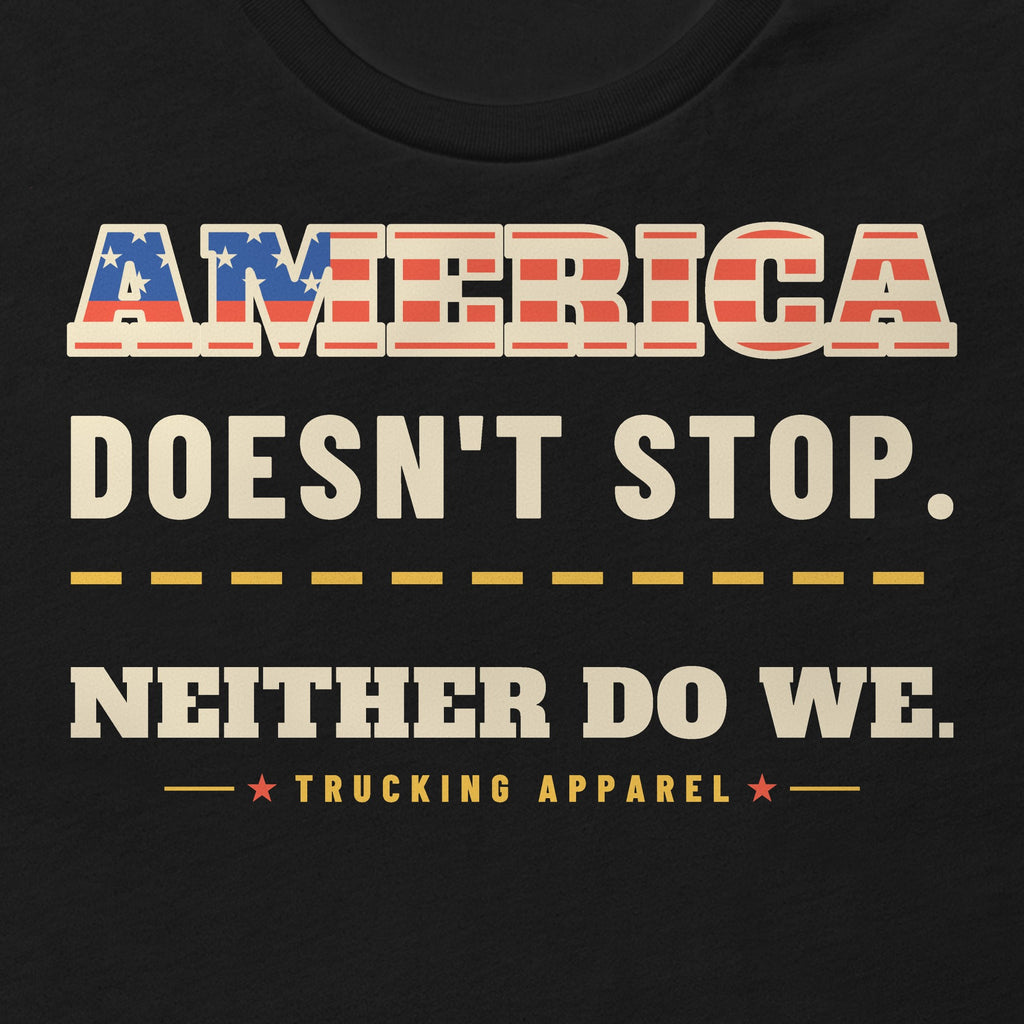 America Doesn't Stop Tee in black, close-up of the AMERICA DOESN'T STOP. NEITHER DO WE. front print with stars-and-stripes lettering.