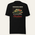 Trucker Mom Tee: My Kid Delivers Christmas in black, front view laid flat showing the full front print, with the Trucking Apparel logo on the left sleeve. Design made with AI assistance.